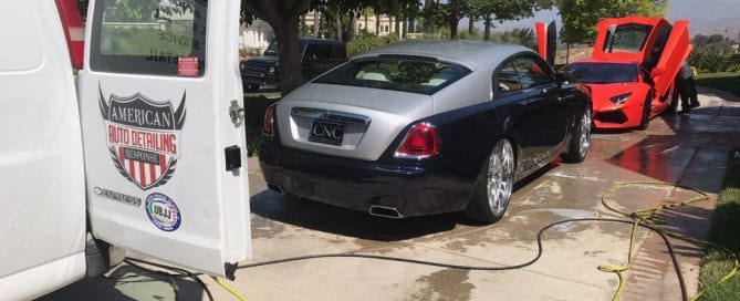 On-site car detailing in progress with American Auto Detailing van and luxury cars.