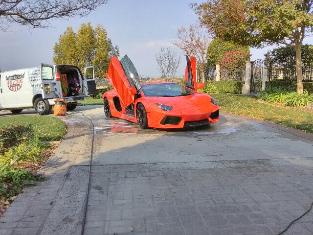 Mobile auto detailing professional polishing a Lamborghini car.