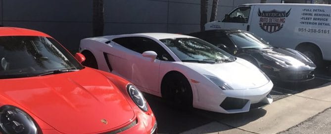Technician polishing car exterior during professional detailing service.